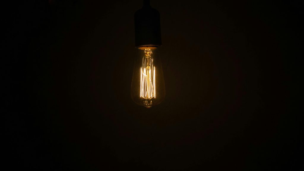 A glowing Edison light bulb against a dark background, showcasing classic design.